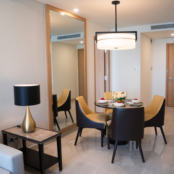 Dining area of comfortable studio flat or hotel room. Set dining table prepared for dinner with Asian cuisine. City apartment and interior concept